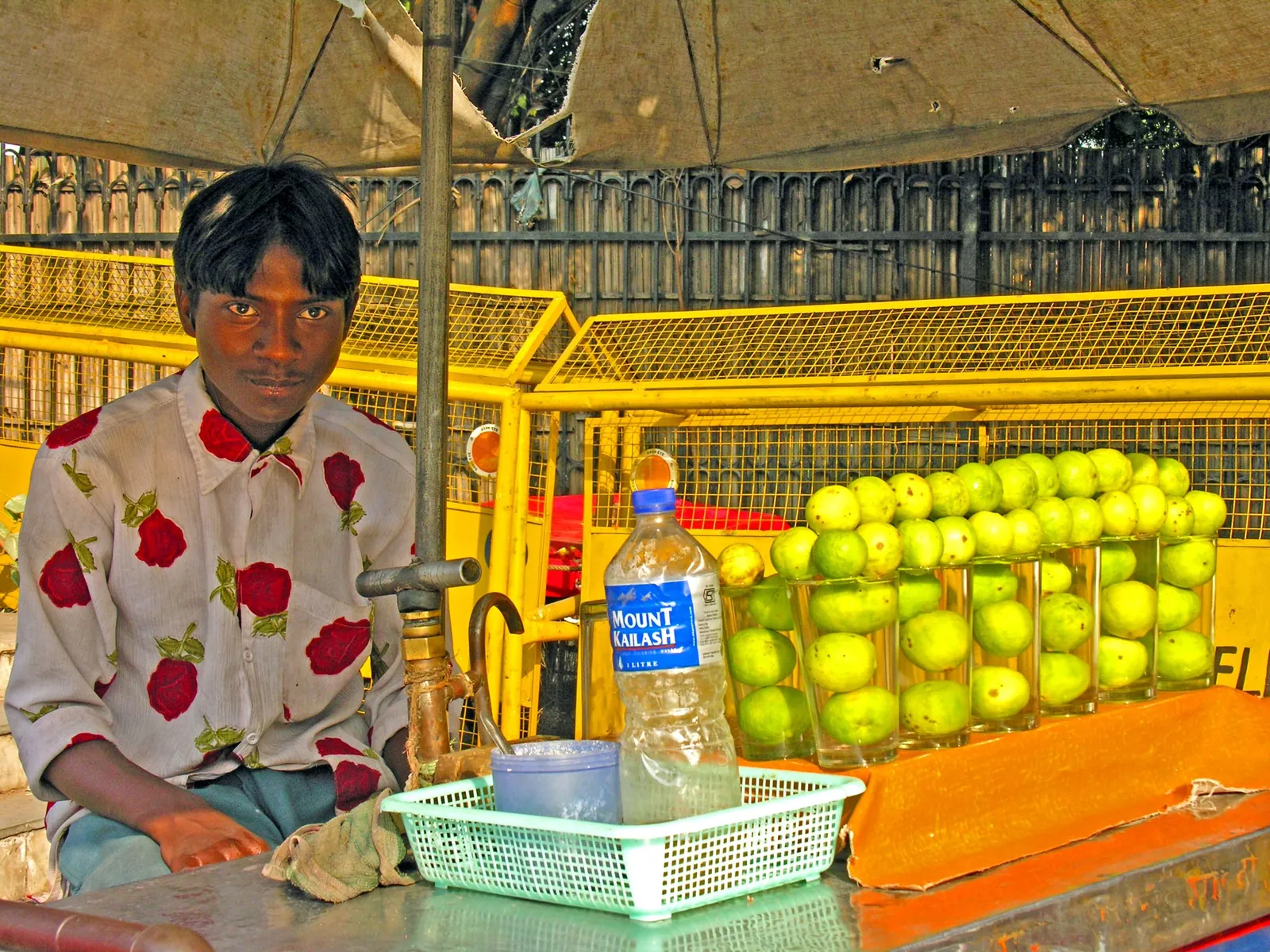 Nimbu pani seller at a roadside stall outside the Red Fort in Delhi, with fresh lemons and a water bottle